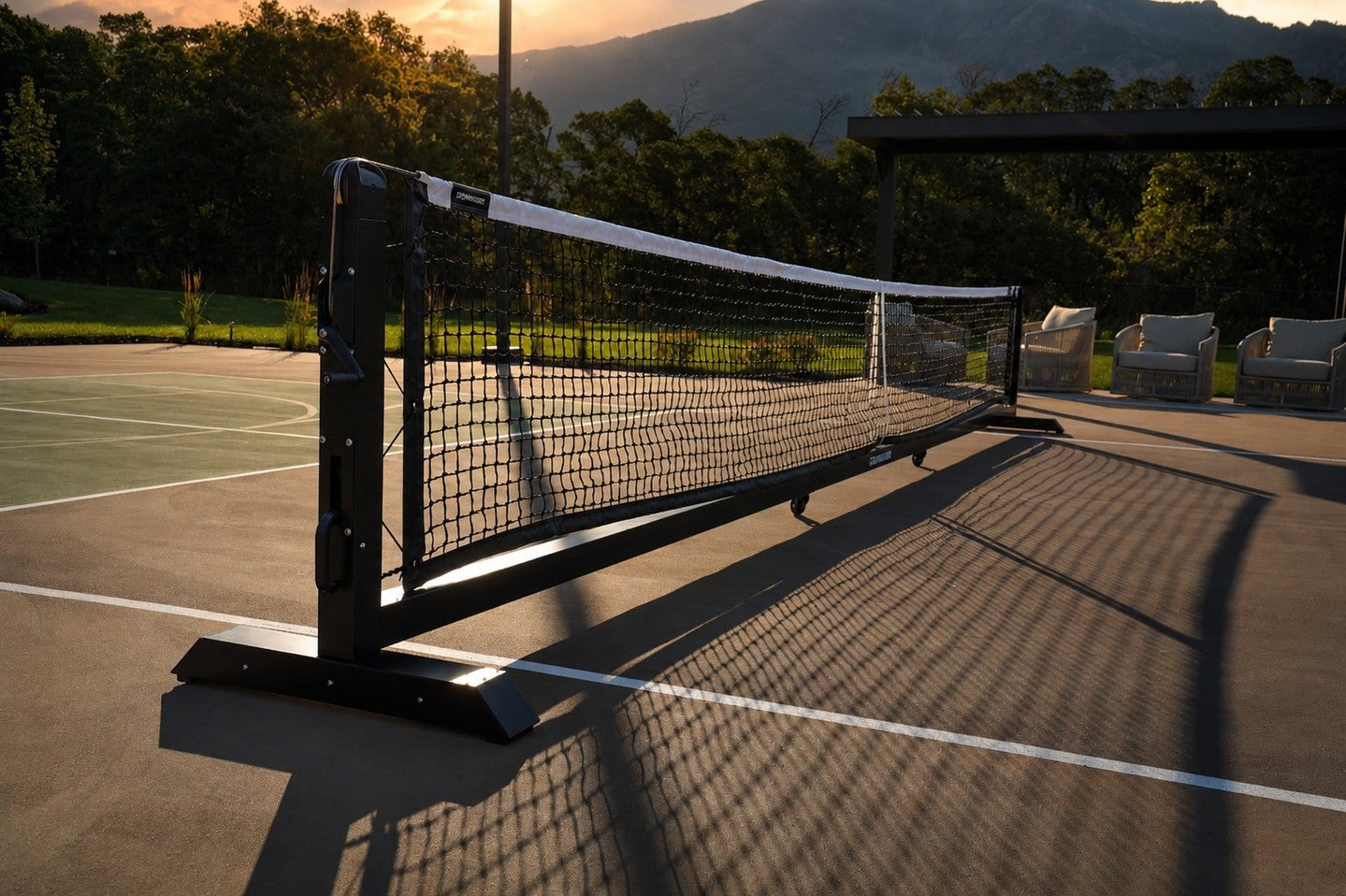Dominator rolling pickleball net on an outdoor court at sunset