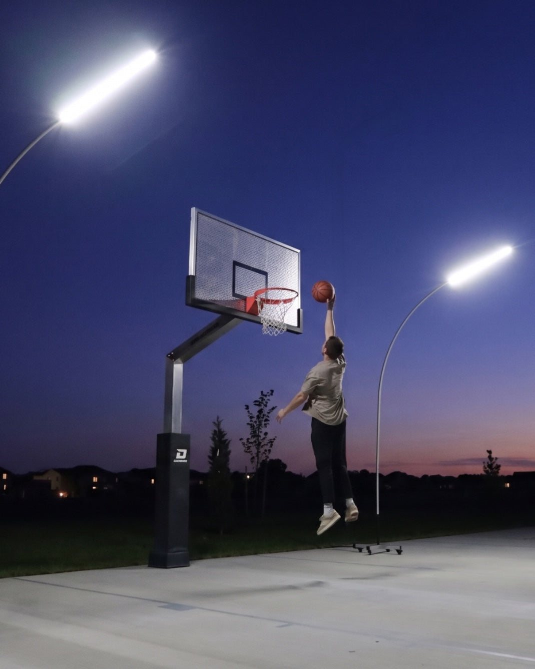 Basketball player at night beneath Dominator court lights