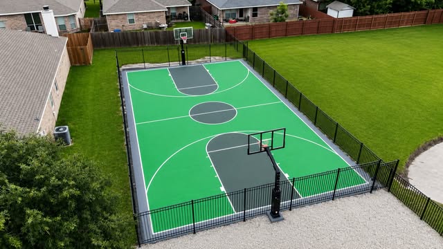 Green backyard basketball court with Dominator hoops at both ends