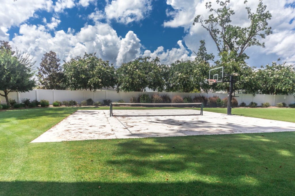 A backyard basketball court and pickleball net